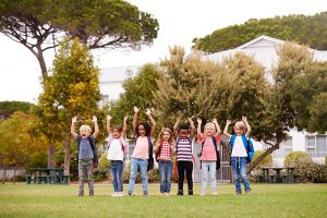 Excited Elementary School Pupils On Playing Field At Break Time